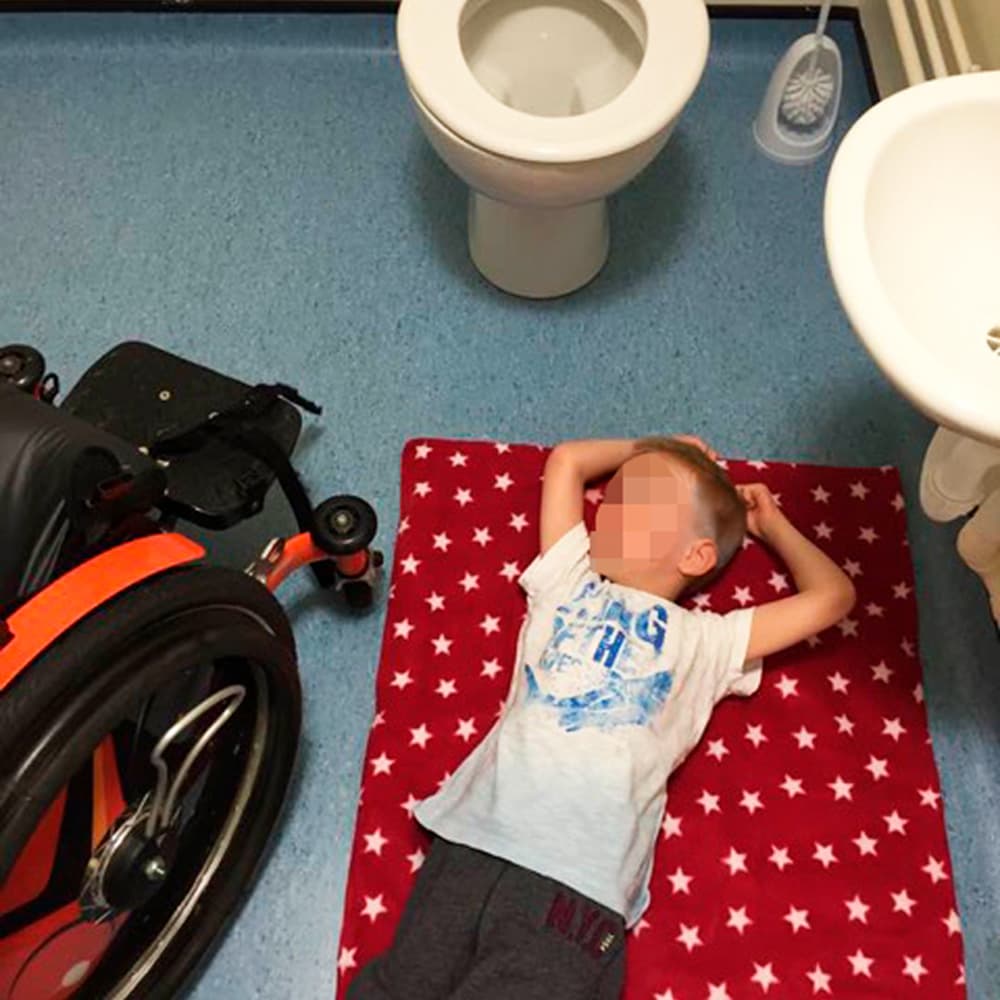 Child being changed on bathroom floor